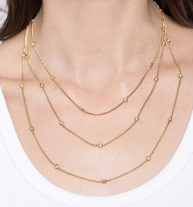 Gros plan sur un collier triple rang en argent S925 doré avec zircons sertis clos