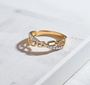 Detail of gold S925 silver ring featuring chain design and pavé cubic zirconia accents