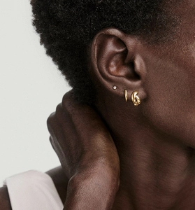 Gros plan de boucles d'oreilles nœud torsadé en argent S925 sur l'oreille