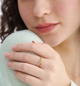 Detailed close-up of 18K gold chain link ring with pavé diamonds on model's finger