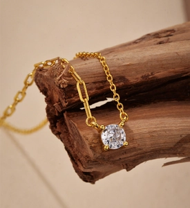 Macro shot of S925 silver gold-plated necklace with zircon pendant on wooden texture