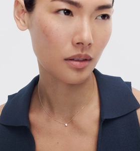 Gros plan d'un collier chaîne dorée avec pendentif en zircone cubique ronde sur le cou