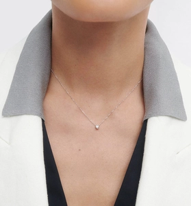 Gros plan d'un collier en argent S925 minimaliste avec zircon rond porté par un mannequin