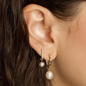 Elegant gold S925 earrings with pearls and pavé diamonds shown on a model
