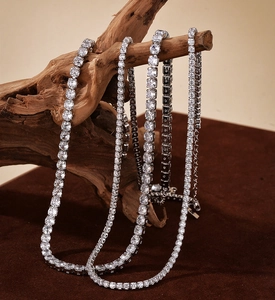 Macro shot of silver S925 tennis necklaces with sparkling zircon stones on wood