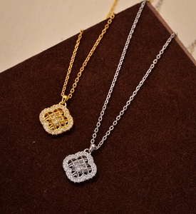 Détails macro des colliers trèfles en argent et or avec zircons micro-pavés et motifs ajourés