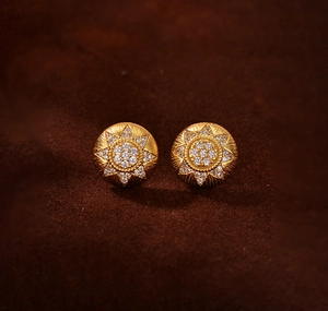 Close-up of gold sunflower stud earrings with brushed metal texture and zircon inlay
