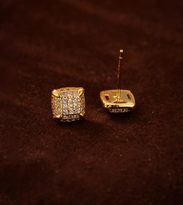 Macro view of geometric square stud earrings featuring 18K gold plating and pavé zircon