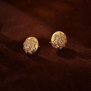 Macro detail of 18K gold plated sunflower stud earrings with shimmering cubic zirconia
