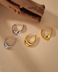 Detail view of twisted S925 silver C-shape earrings in polished gold and silver finishes
