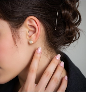 Close-up of luxury 18K gold plated square zircon stud earrings worn by a model