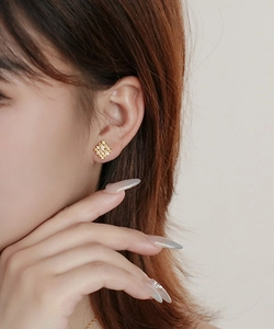 On-ear shot of 18K gold plated S925 silver stud with hollow geometric lattice design