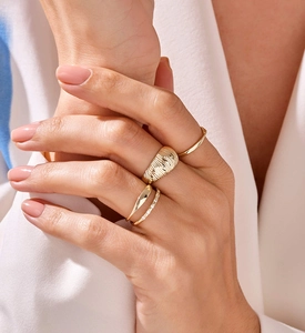 Close-up of minimalist gold ring set featuring textured band and sparkling zircons