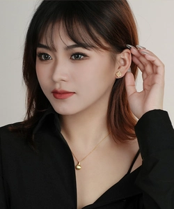Close-up of a model wearing 18K gold plated S925 silver quilted diamond stud earrings