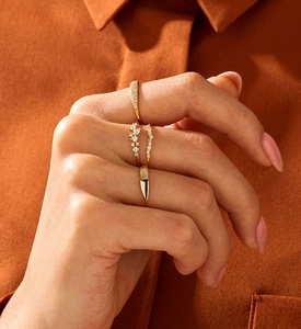Detail of four-piece minimalist gold ring set featuring pave-set zircons on hand
