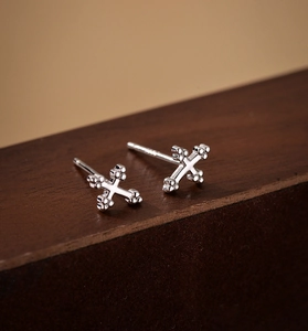 Macro shot of minimalist S925 sterling silver cross stud earrings with rounded ends