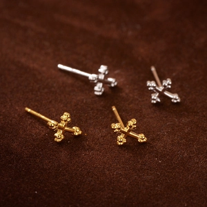 Macro shot of minimalist S925 sterling silver cross stud earrings in gold and silver finish