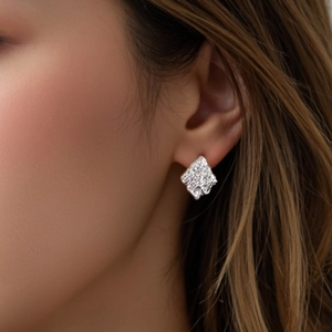 Boucles d'oreilles carrées argentées à texture irrégulière portées par un mannequin chic