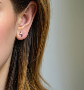 Close-up of minimalist S925 sterling silver cross stud earring worn on model's ear