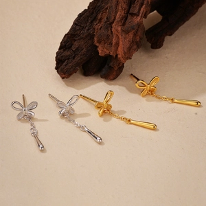 Macro detail of butterfly tassel earrings in gold and silver plating with droplet charms
