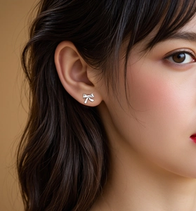 Gros plan de boucles d'oreilles nœud en argent S925 montrant le détail poli sur l'oreille