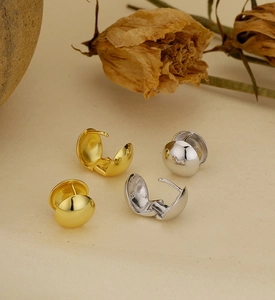 Gros plan sur les créoles boules en argent 925 avec finition miroir dorée et argentée
