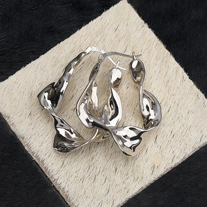 Orecchini a cerchio in argento sterling S925 con design a torsione liquida su sfondo di pelliccia