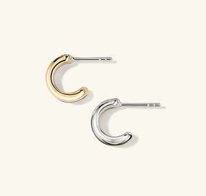 Gros plan de boucles d'oreilles créoles en forme de C bicolores or 18 carats et argent