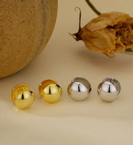 Vue macro de boucles d'oreilles boules minimalistes en argent 925 finitions or et argent