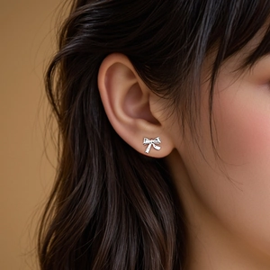 Élégantes boucles d'oreilles nœud en argent S925 portées sur l'oreille pour un style chic
