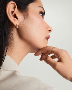 Détail de boucles d'oreilles clous en forme de C bicolores or 18 carats et argent sur modèle