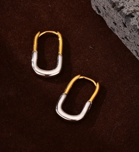 Detail of two-tone U-shape hoop earrings in polished gold and silver minimalist finish