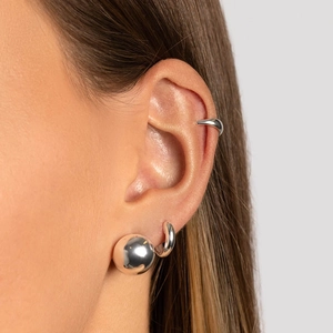 Vue détaillée de la boucle d'oreille à bille en argent poli et du ear cuff sur l'oreille