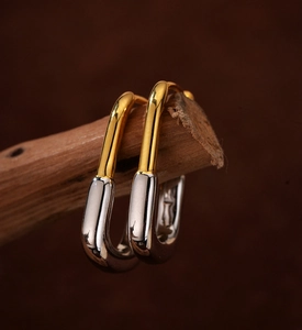 Macro view of geometric U-shaped earrings in polished gold and silver two-tone finish