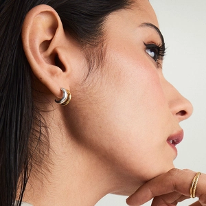 Boucles d'oreilles élégantes en forme de C bicolores or et argent sur un mannequin