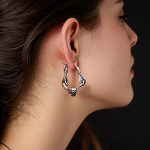 Eleganti orecchini a cerchio attorcigliati in argento S925 indossati da una modella