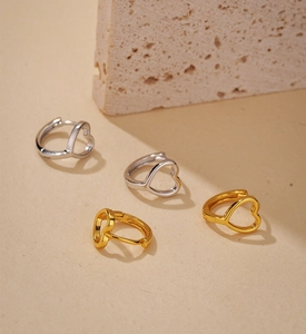 Dettaglio di orecchini a cerchio minimalisti a cuore cavo in finitura oro e argento