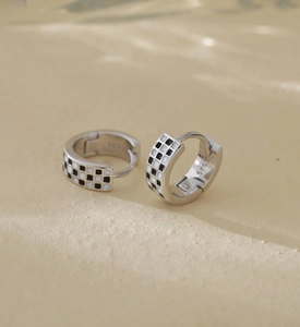 Détail de boucles d'oreilles créoles en argent S925 avec émail en damier noir et blanc