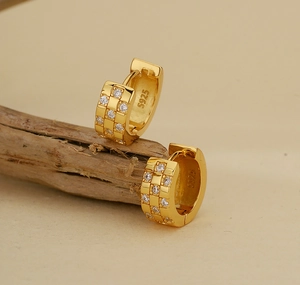 Macro detail of gold checkered pave earrings with S925 sterling silver hallmark