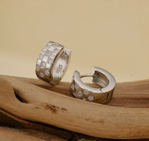 Macro shot of S925 sterling silver stamp and micro-paved zircon checkered hoop earrings