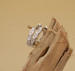 Vue détaillée des créoles en argent 925 avec zircons rectangulaires sur bois