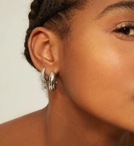 Détail macro de boucles d'oreilles en U argent S925 avec pavé de zircone et métal poli brillant