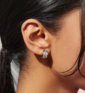 Close-up of S925 silver huggie earrings with checkered zircon inlay on female ear