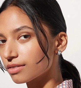 Detail of silver S925 sterling silver hoop earring with checkered zircon pave on model ear