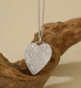 Nahaufnahme des S925 Sterlingsilber Herzanhängers mit Diamanten auf einem Holzzweig