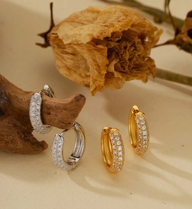 Detailed view of gold and silver S925 sterling silver hoop earrings with pavé crystals