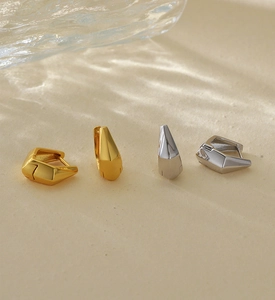 Close-up of geometric S925 sterling silver hoop earrings in gold and silver finishes