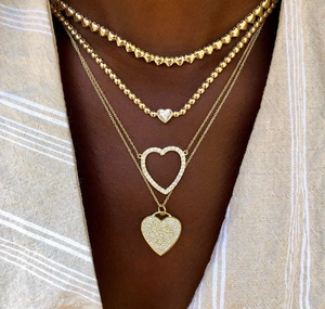 Detail eines vierlagigen goldenen Herzanhänger-Halskettensets mit Zirkonia-Diamanten