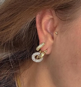 Detail of elegant gold-plated hoop earrings with micro-pave rhinestones on a female model