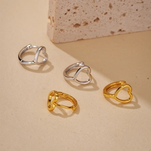 Orecchini a cerchio a cuore vuoto in oro e argento esposti su pietra naturale